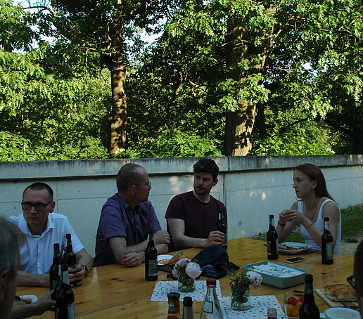 4 Personen sitzen am Tisch
