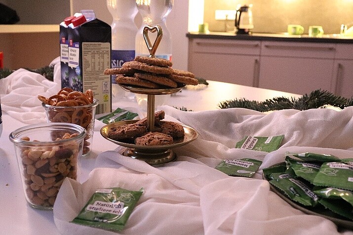 Gebäck und Knabbereien auf einer weißen Tischdecke.