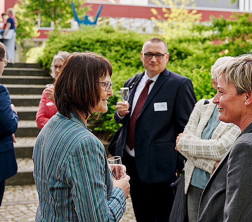 Eine Gruppe Frauen und Prof. Knoll beim Get Together in der Aula.