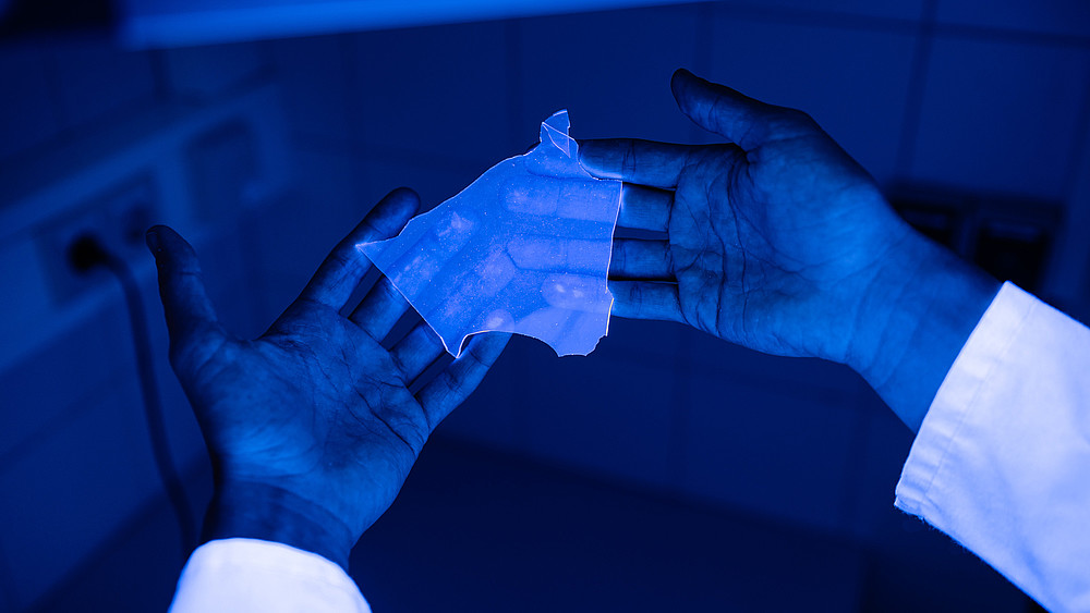 An der HSZG synthetisiertes Silikon, welches mit einem Fluoreszenzfarbstoff markiert ist, liegt in zwei geöffneten Händen.