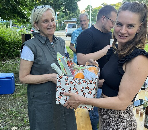 1 Person übergibt ein Geschenk