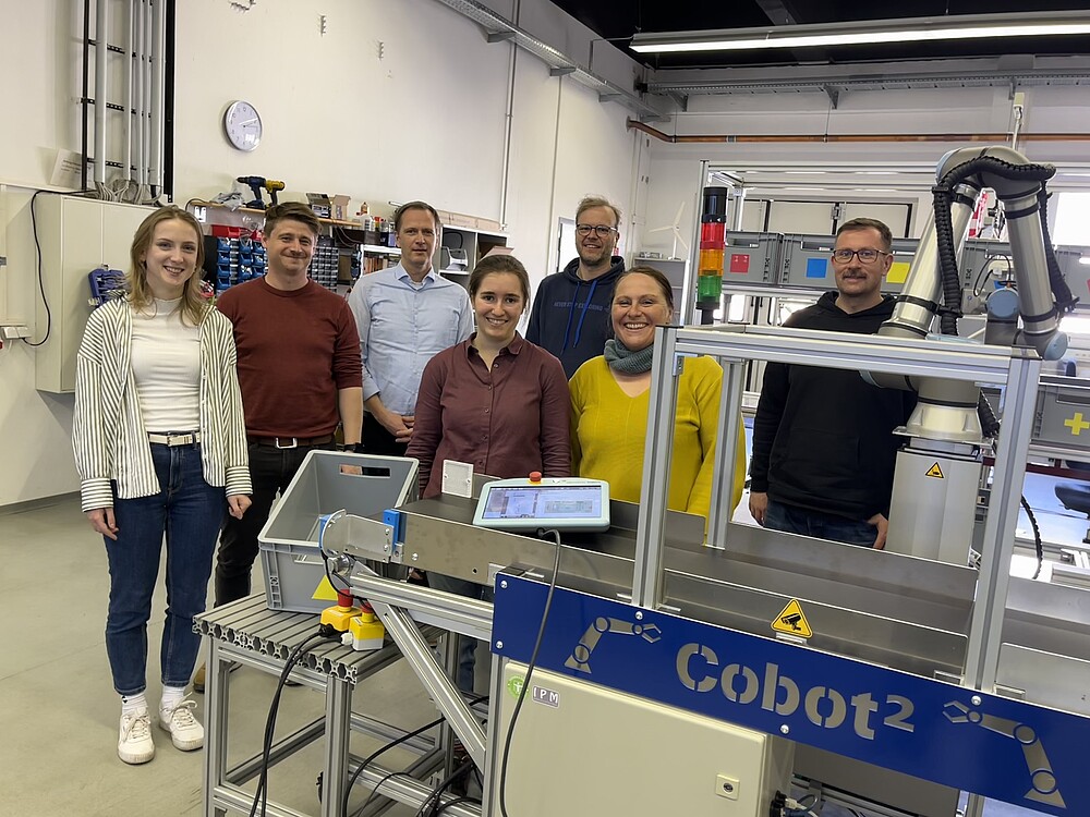 Projektbeteigte Menschen vor der Cobot-Anlage