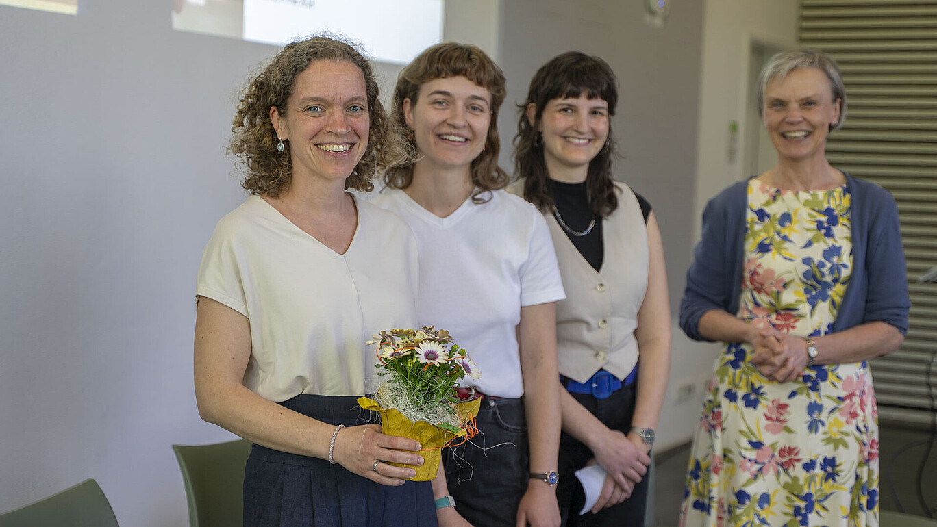 Steffi Heidig, die Moderatorinnen und die Prorektorin stehen zum Gruppenbild lächelnd nebeneinander in der Aula.