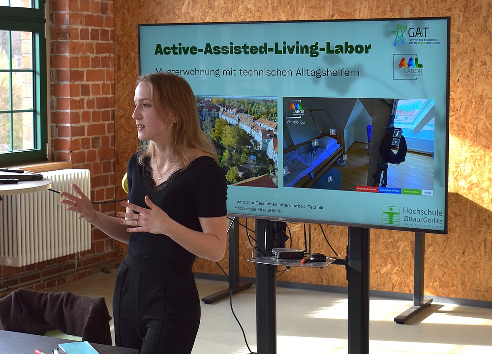 Frau referiert vor einem Monitor