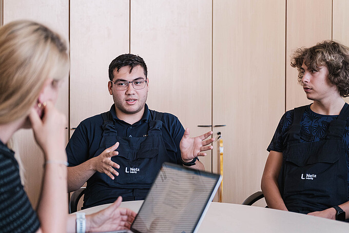 KIA-Studierende im Gespräch in einem Sitzungssaal an einem Tisch.